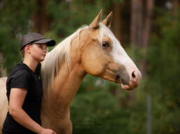 Person mit Pferd zur Seite blickend, fotografiert von LiraAmarokPictures