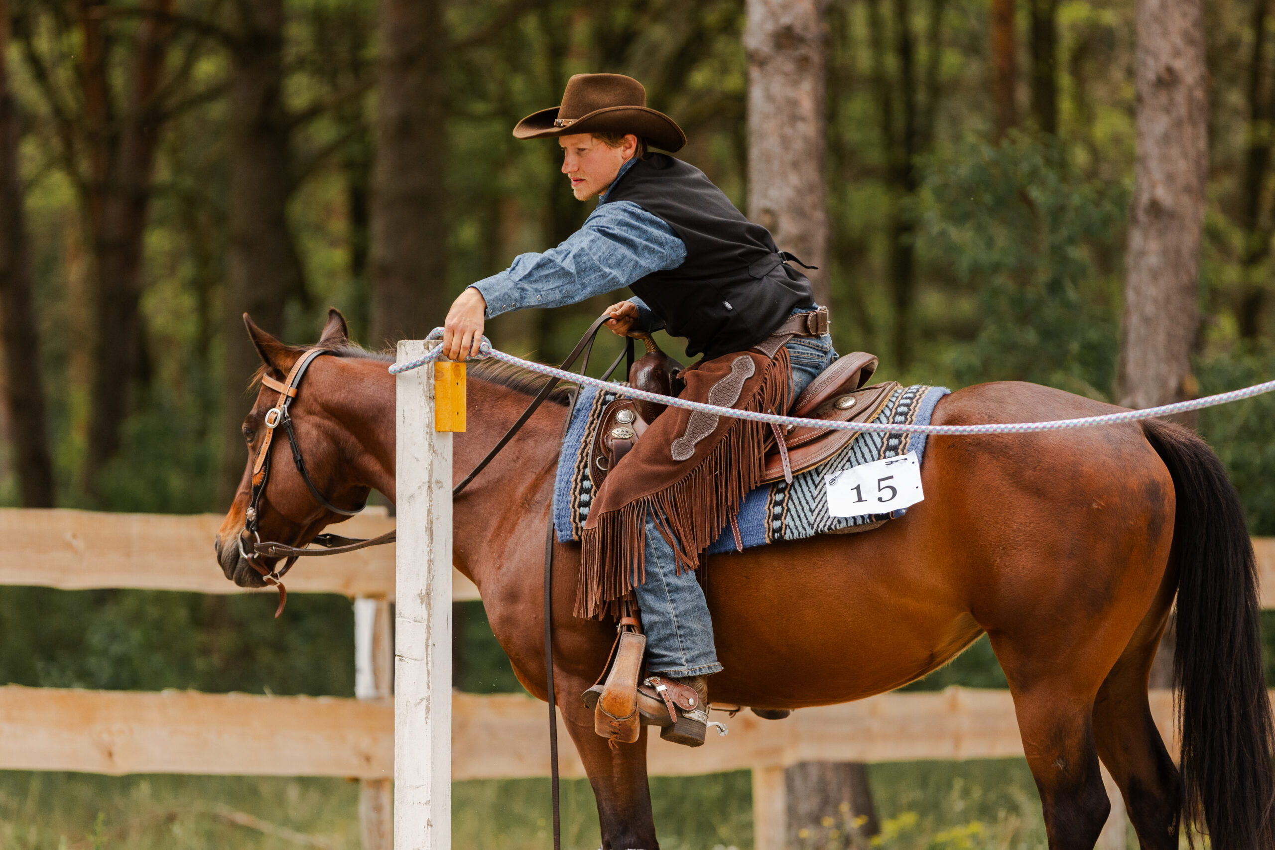 Ein Reiter mit seinem Pferd beim Tor öffnen beim Trail