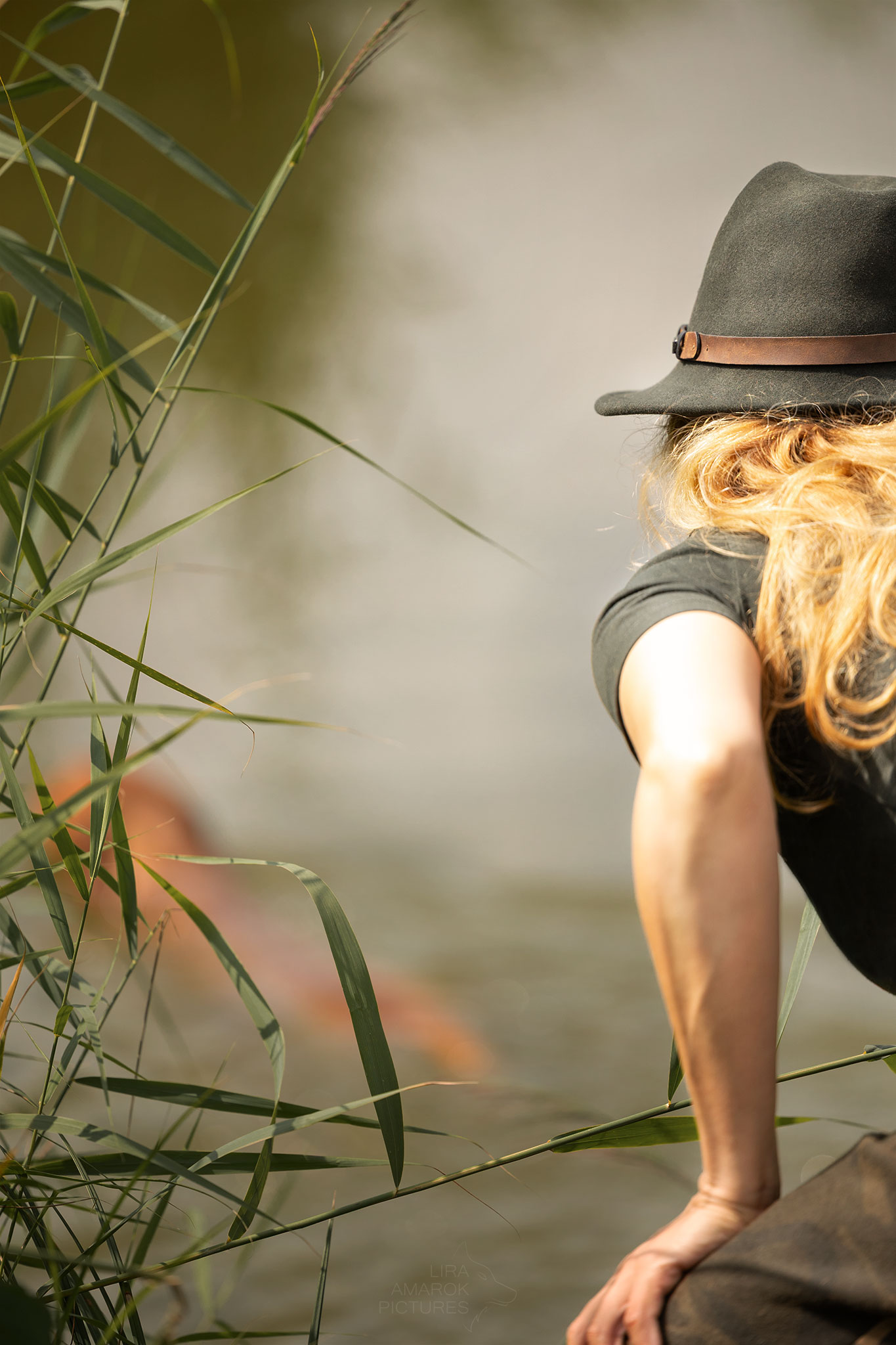 Eine Frau von hinten mit einem Hund im Wasser