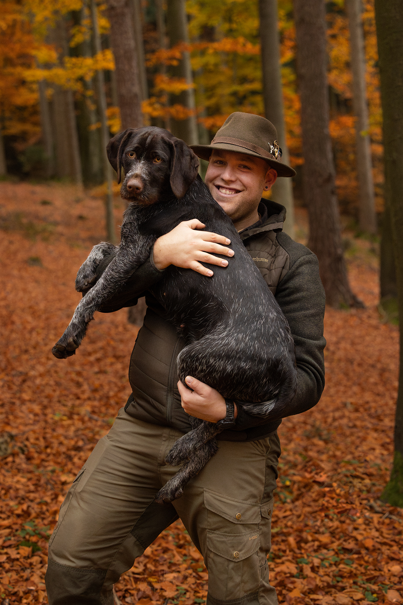 Ein Jäger mit seinem Deutsch Drahthaar auf dem Arm