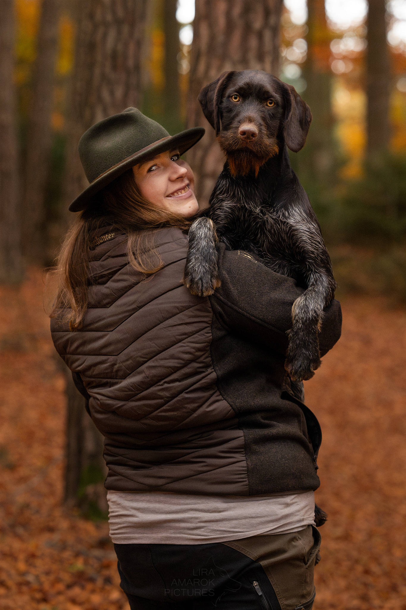 Jägerin hat ihren Jagdhund auf dem Arm